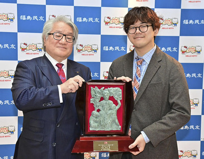 みんゆう県民大賞を受賞し、野崎社長から盾を受ける鈴木さん（右）＝２５日午前、郡山市・岩瀬書店富久山店