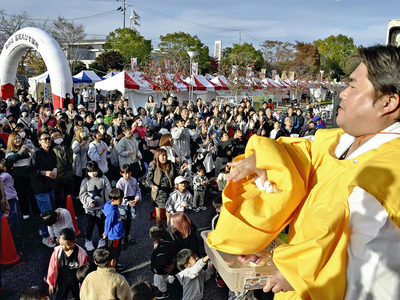 餅投げの催しでにぎわう会場＝富岡町・学びの森駐車場