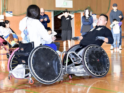 参加者にタックルを体験してもらう橋本選手